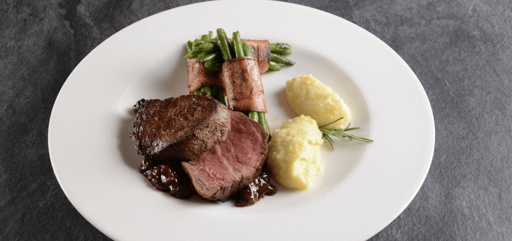 Rezept: Rinderfilet (Uruguay) mit Speckfisolen und Trüffelpüree! Mit Salz und Pfeffer würzen, auf Zimmertemperatur bringen und in einer heißen Pfanne scharf anbraten. Das Filet in der Pfanne in den Ofen stellen und auf 62 C° Kerntemperatur bei 120 C° fertig braten. Wiesbauer Gourmet