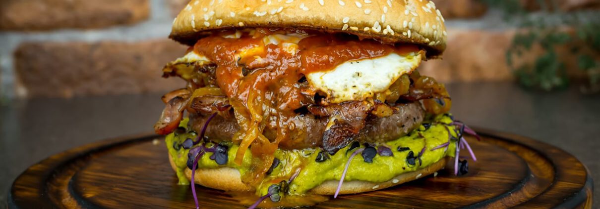 Dry Aged Beef Burger mit Fried-Pickled-Onions und Erbsenpüree