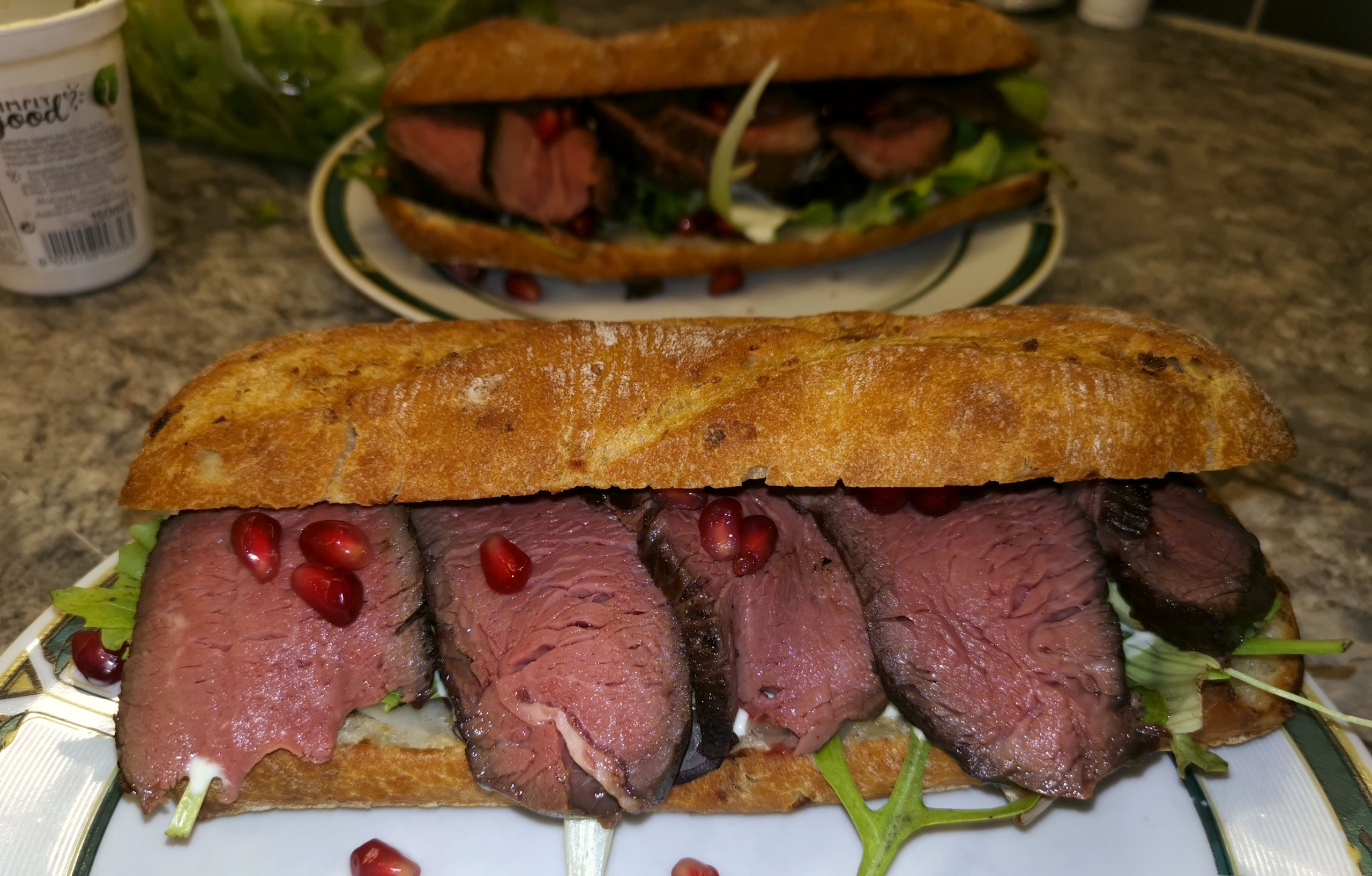 Filetsteak auf Zwiebelbaguette mit Caesar Salad und Granatapfelkernen