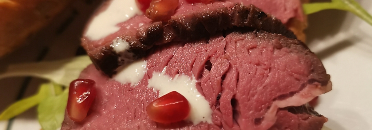 Filetsteak auf Zwiebelbaguette mit Caesar Salad und Granatapfelkernen