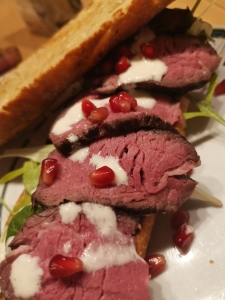 Filetsteak auf Zwiebelbaguette mit Caesar Salad und Granatapfelkernen